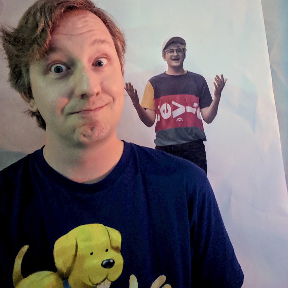 Me standing in front of a small picture of @infiniteelliott