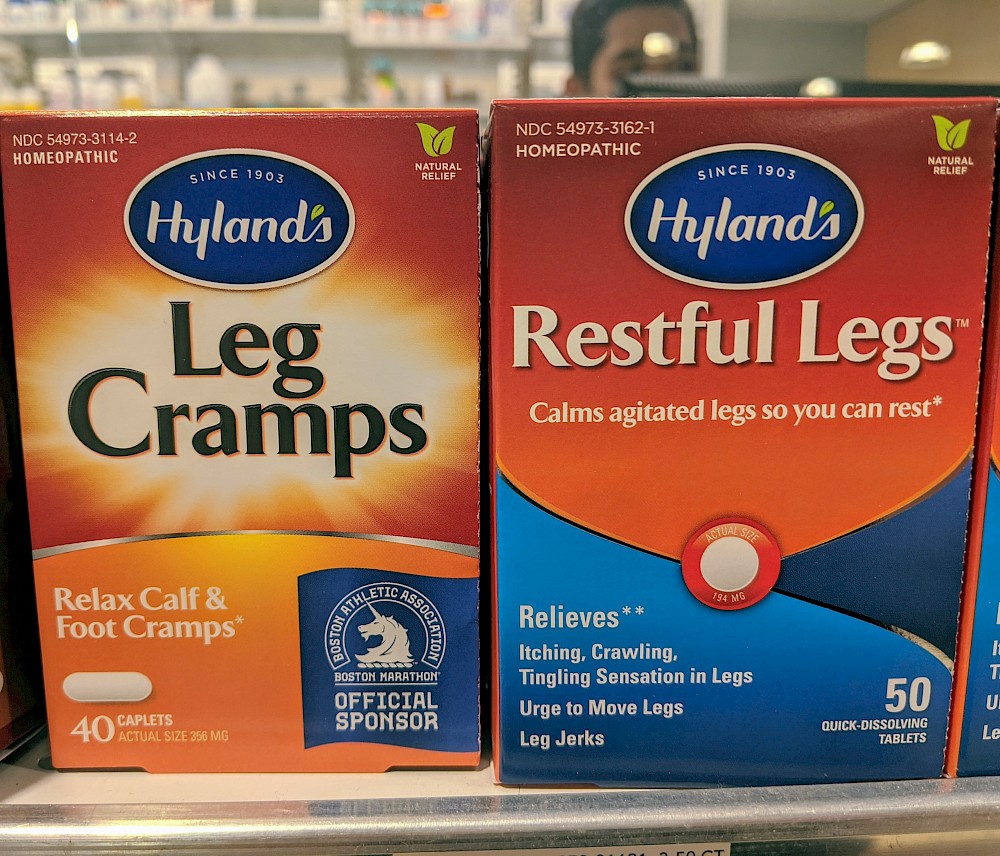 two boxes of medicine; left one labeled 'Leg Cramps' and right one labeled 'Restful Legs'