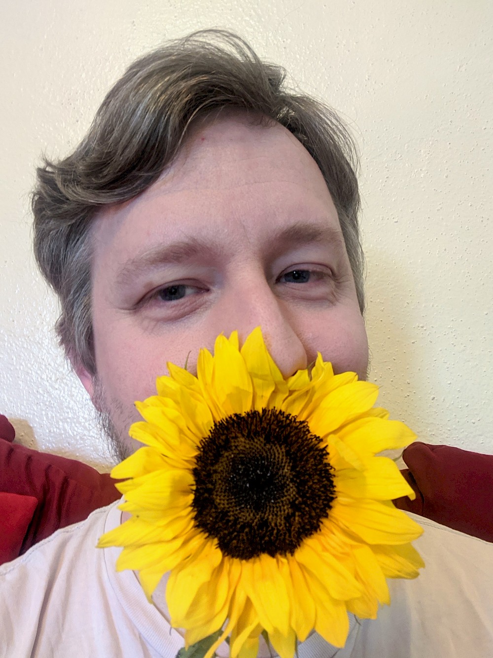 selfie holding a sunflower over my mouth and chin