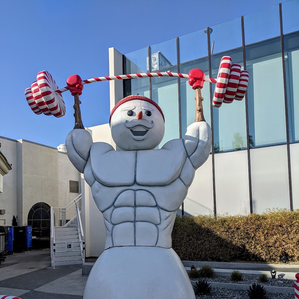 statue of a muscular snowman lifting weights