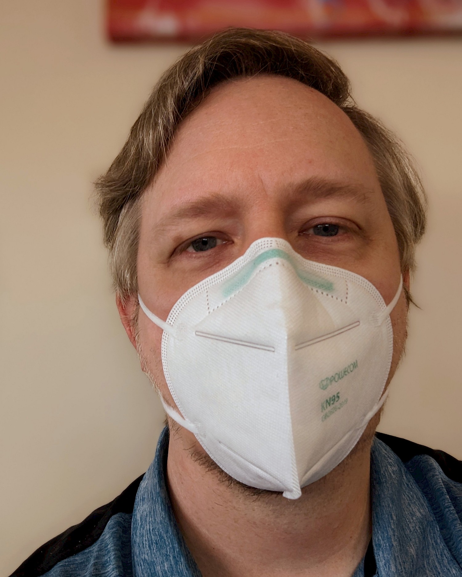 selfie while wearing a white KN95 mask, sitting in the cardiologist's waiting area