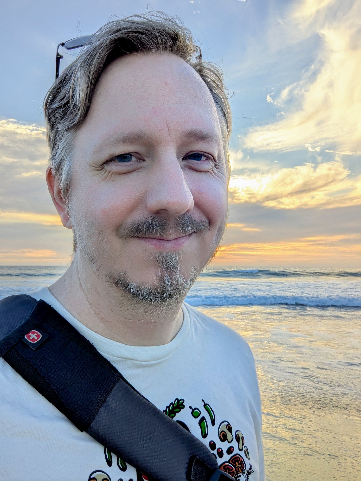 A smiling selfie at the beach with the ocean in the background